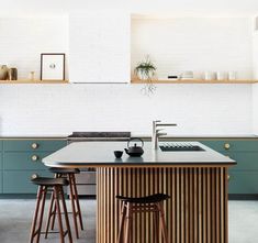 a kitchen island with stools in front of it