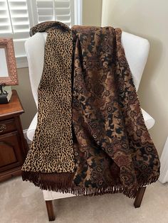 a leopard print blanket sitting on top of a white chair