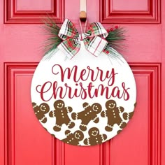 a red door with a merry christmas ornament hanging on it