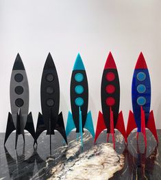 a group of toy rockets sitting on top of a marble counter next to each other