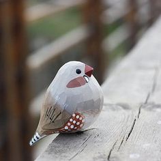 a small bird sitting on top of a wooden bench