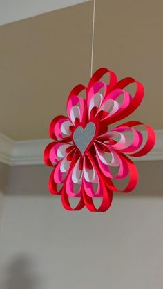 a heart shaped paper decoration hanging from a ceiling