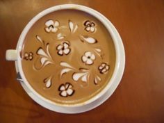 a white cup filled with liquid on top of a wooden table