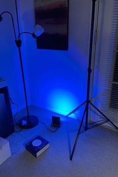 a blue light is shining on the floor in front of a television and other electronics