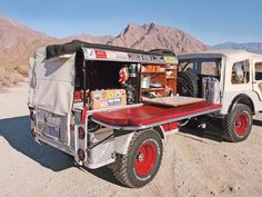 an off - road vehicle is parked in the desert with its door open and luggage on it's back