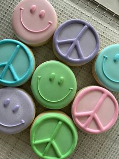 decorated cupcakes with smiley faces and peace signs on them sitting on a table