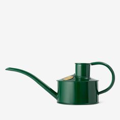 a green watering can with a long handle and a gold cap on the top, sitting in front of a white background