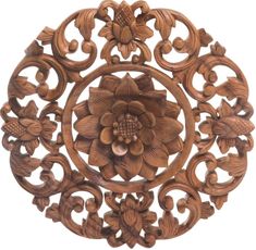 an intricately carved wooden wall hanging with flowers and leaves on the center, surrounded by filigrees