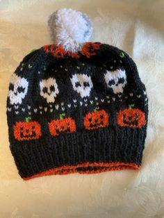 a knitted hat with skulls and pumpkins on it