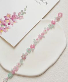 a close up of a piece of paper with flowers on it and a card next to it