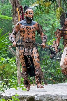 two men in costumes walking through the jungle