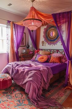 a bedroom decorated in purple and orange with a canopy bed covered in pink drapes