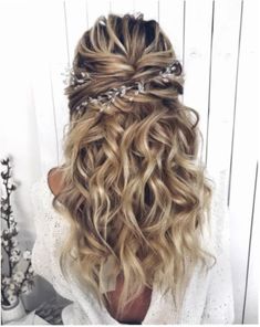 the back of a woman's head with wavy hair and braids in it