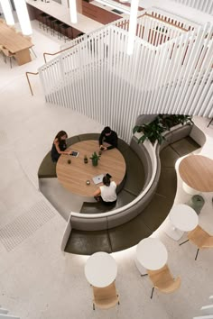 two people are sitting at a table in the middle of a room with chairs and tables