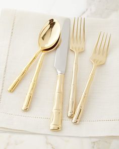 gold colored utensils and spoons on a white napkin