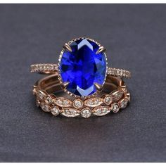 an oval blue sapphire and diamond ring set on top of each other with two matching bands