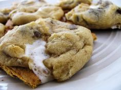 some cookies are on a white plate and one is smothered with icing