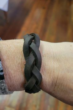 a person wearing a black leather bracelet on their arm