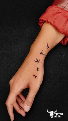 a person's hand with birds on it