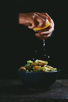 a person pouring water over a bowl filled with food