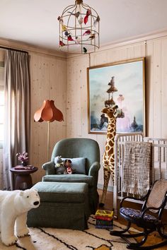 a baby's room with a giraffe painting on the wall and rocking chair