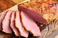 sliced meat sitting on top of a wooden cutting board