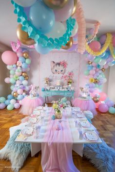 a cat themed birthday party with balloons, streamers and table cloths in pastel colors