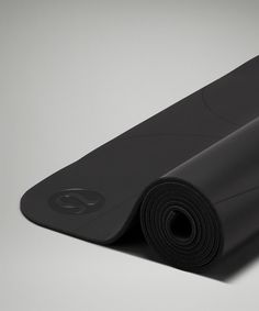 a black yoga mat rolled up on the floor