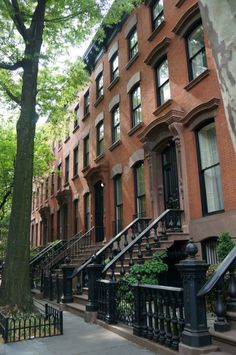 a row of brownstone townhouses with wrought iron railings