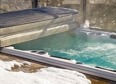 an outdoor hot tub with snow on the ground