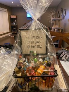 a basket filled with lots of bottles and plastic wrap on top of a wooden table