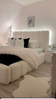 a large white bed sitting inside of a bedroom