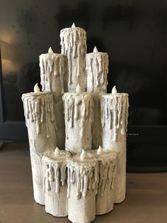 a group of white candles sitting on top of a wooden table