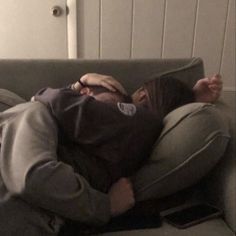 a man laying on top of a couch with his head in the air while covering his eyes