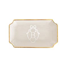 a white and gold tray with a monogrammed b on the bottom, in front of a white background