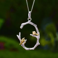 "Capture the beauty of nature's harmony with our sterling silver and gold pendant, delicately crafted in the shape of a curved C-shaped branch, adorned with two charming birds perched in perfect symmetry. 🌿🐦 This exquisite piece embodies the tranquility and grace of avian life, symbolizing unity, companionship, and the boundless spirit of freedom. Elevate your style with this timeless pendant that celebrates the enduring bond between nature and all its creatures, adding a touch of elegance and Branch Necklace, Gold Jewelry Sets, Handmade Fine Jewelry, Bird On Branch, Bird Necklace, 18k Gold Jewelry, Nature Inspired Jewelry, Ring Pendant Necklace, Sterling Silver Necklace Pendants