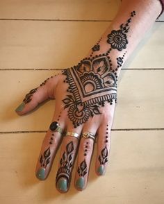 a woman's hand with henna tattoos on it