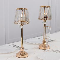 two clear glass candlesticks sitting on top of a table