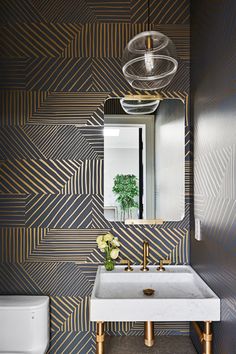 a bathroom sink sitting under a mirror next to a wall mounted faucet