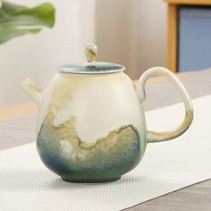 a ceramic teapot sitting on top of a table