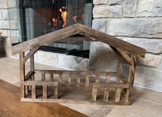 a small wooden house sitting on top of a floor next to a fire place in a fireplace