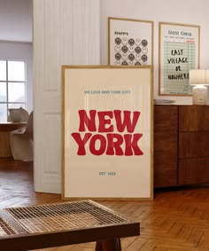 there is a new york poster in the corner of this room with wood flooring