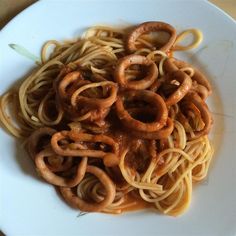 pasta with sauce and onions on a white plate