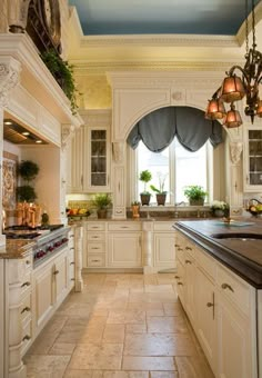 a large kitchen with white cabinets and black counter tops, along with marble flooring