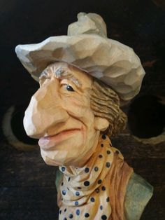 a statue of a man wearing a hat and polka dot scarf with his eyes closed