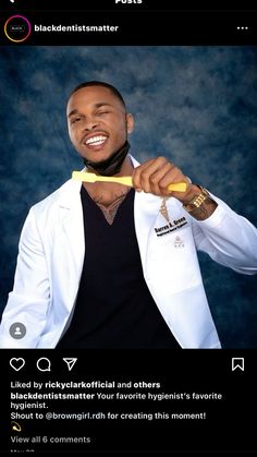 a man holding a toothbrush in his right hand while wearing a white jacket and black t - shirt