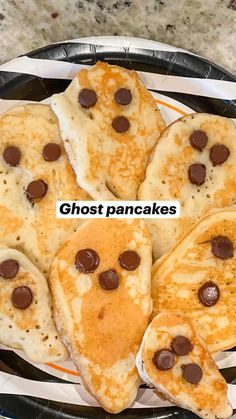 some pancakes with chocolate chips on them and the words ghost pancakes in front of them