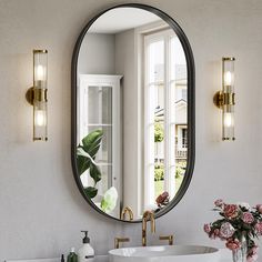 a bathroom sink sitting under a mirror next to a wall mounted faucet in front of a window