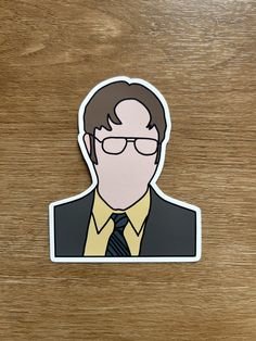 a sticker of a man wearing glasses and a tie on top of a wooden table