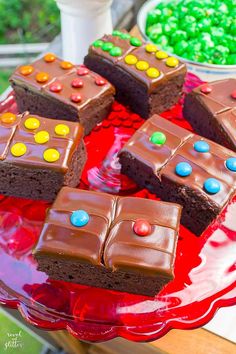 a red plate topped with brownies covered in candy